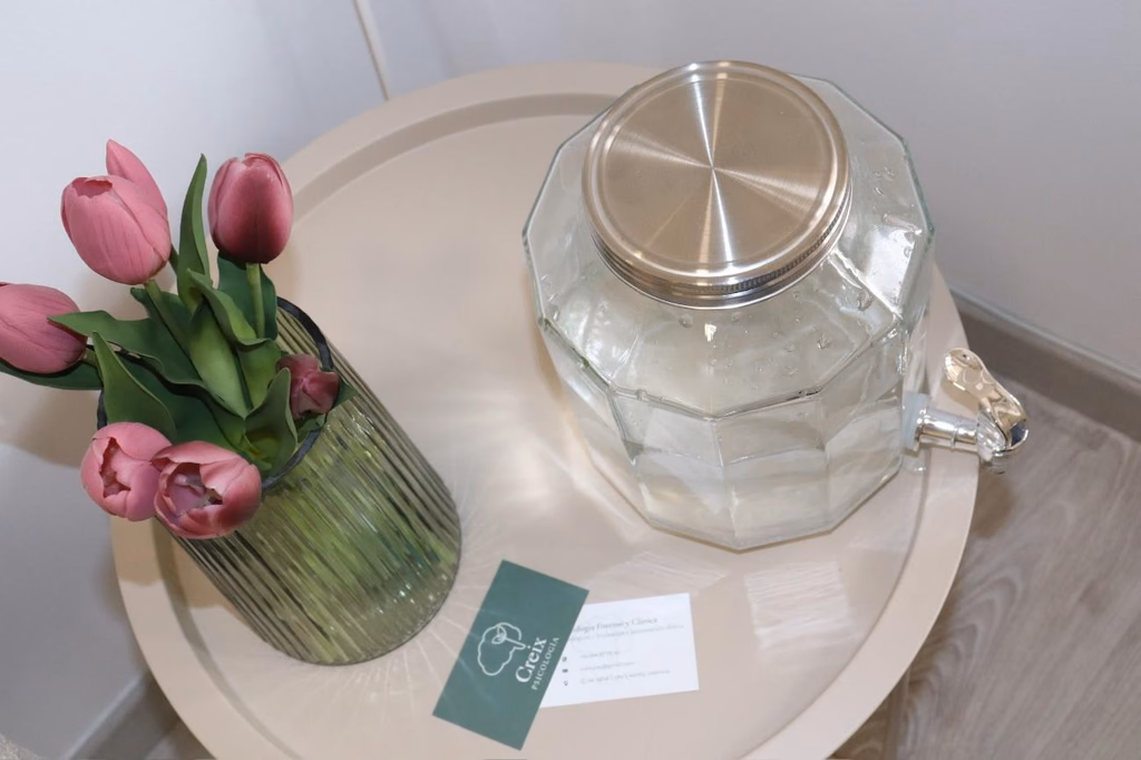Mesa auxiliar con un jarrón de tulipanes y tarjetas de Creix Psicología