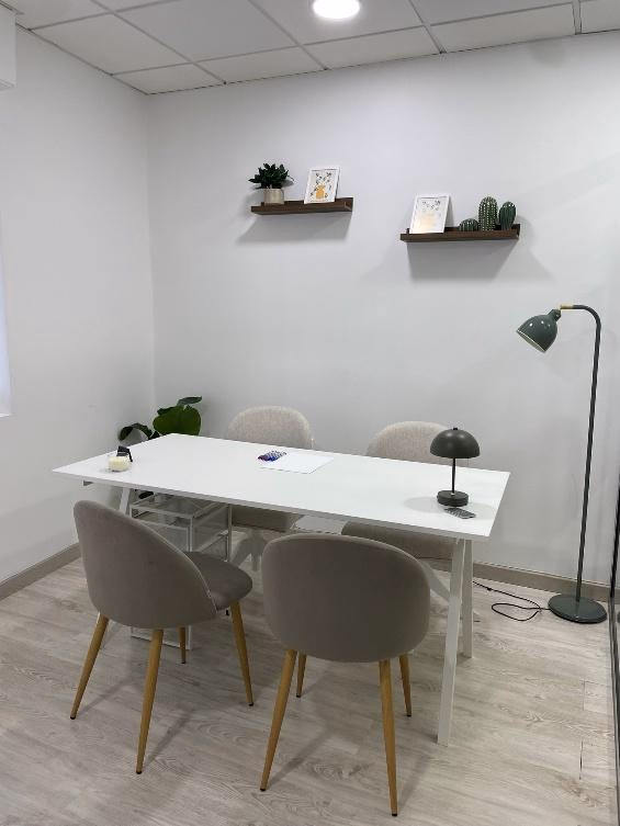 Mesa principal de la consulta de Creix Psicología rodeada de sillas